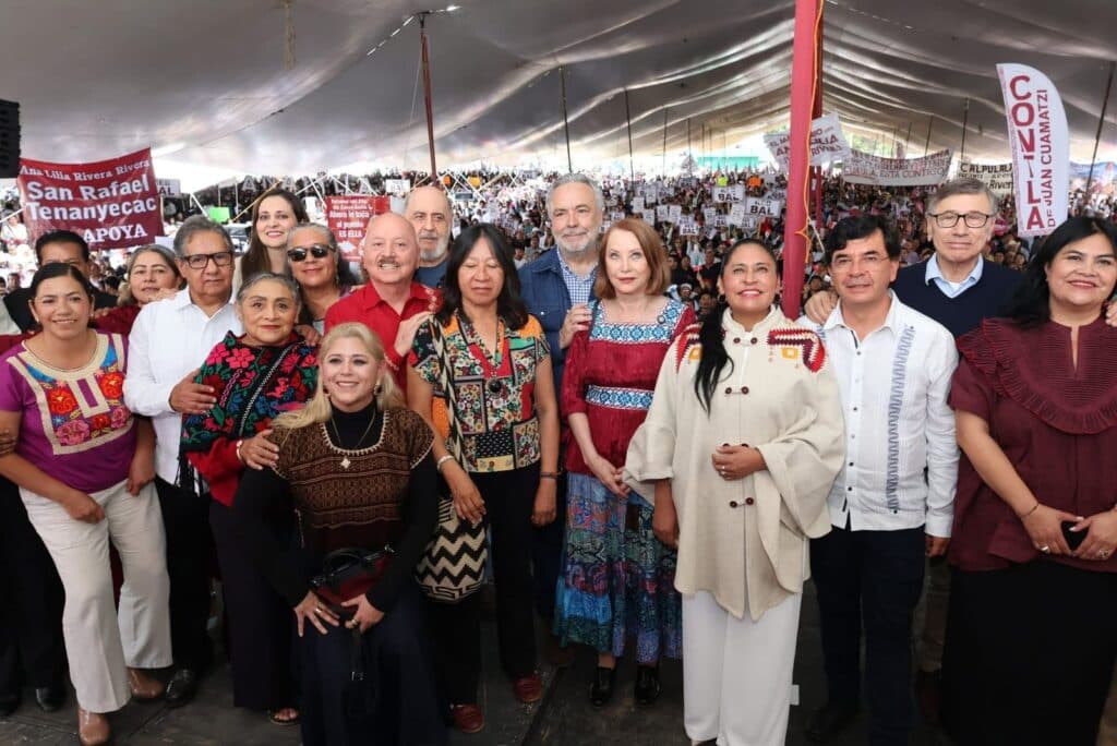 Senadora Ana Lilia Rivera junto a un grupo de asistentes en su Segundo Informe de Actividades, con pancartas y un gran público en Tlaxcala.