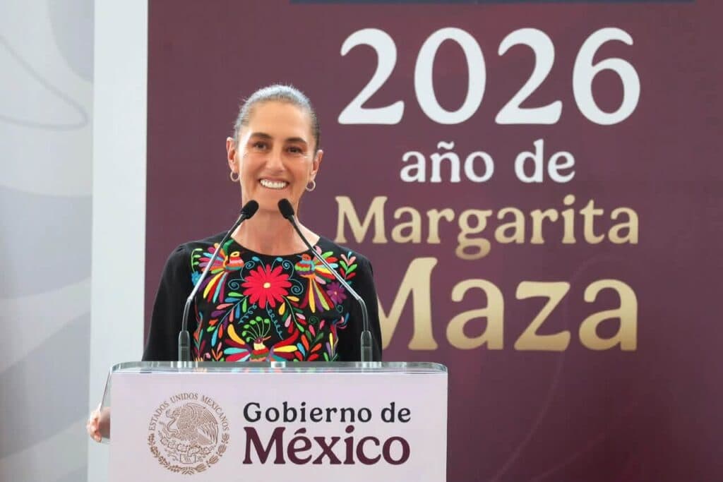 Claudia Sheinbaum sonríe mientras se dirige al público desde un podio con el emblema del Gobierno de México, en un evento de 2026.