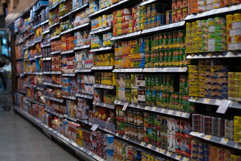 Estantes de supermercado repletos de productos enlatados y envasados, reflejando la variedad de alimentos que podrían verse